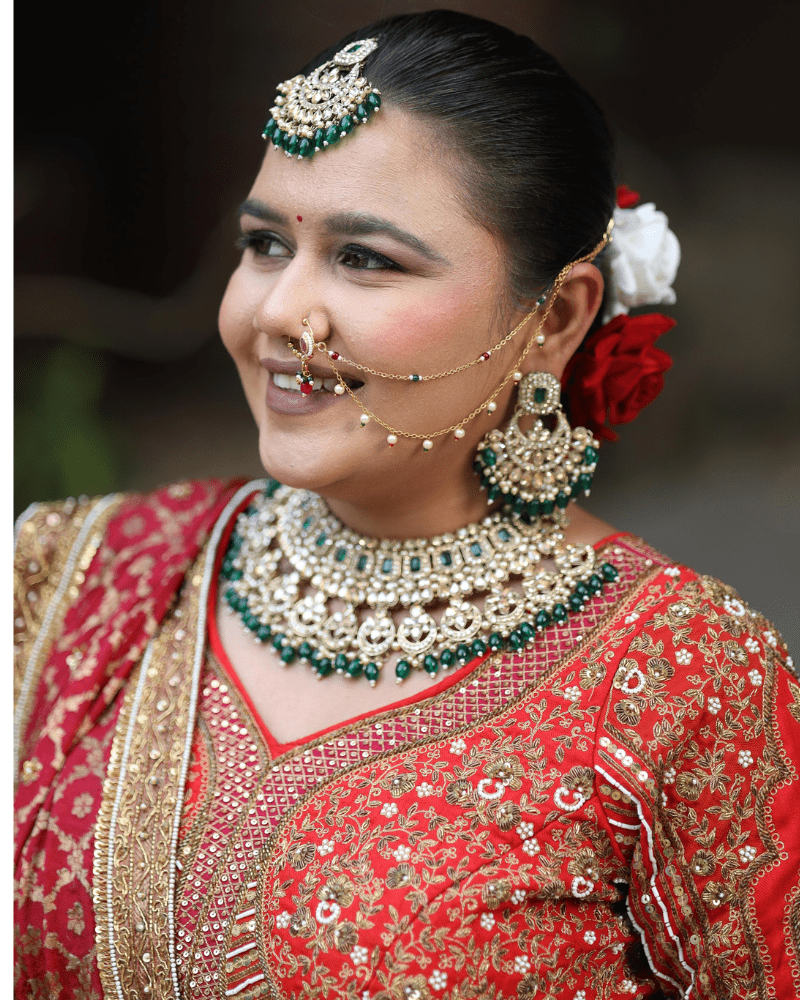 Closeup of bridal jewellery and makeup with red lehenga by Radharani Vastralaya Ahmedabad