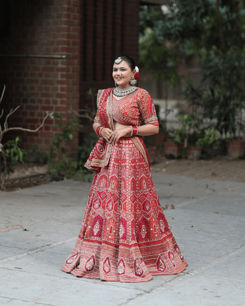 Bridal red lehenga by Radharani Vastralaya Ahmedabad for wedding with heavy embroidery design